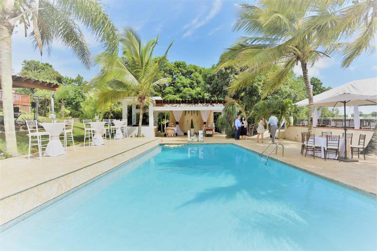 La piscina de la hacienda rodeada de palmas reales y jardines